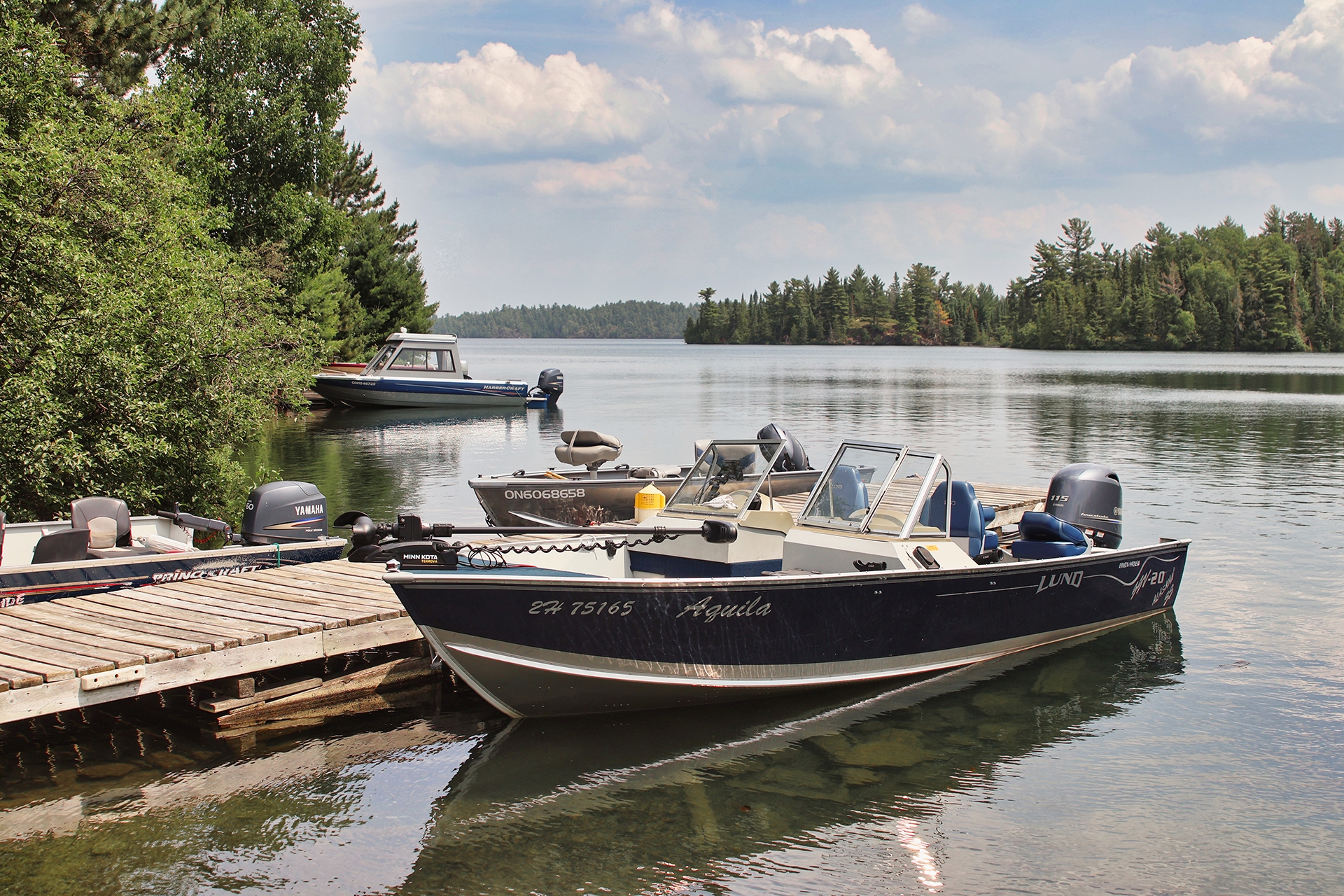 A few fishing boats are tied up at the dock on a bright sunny day
