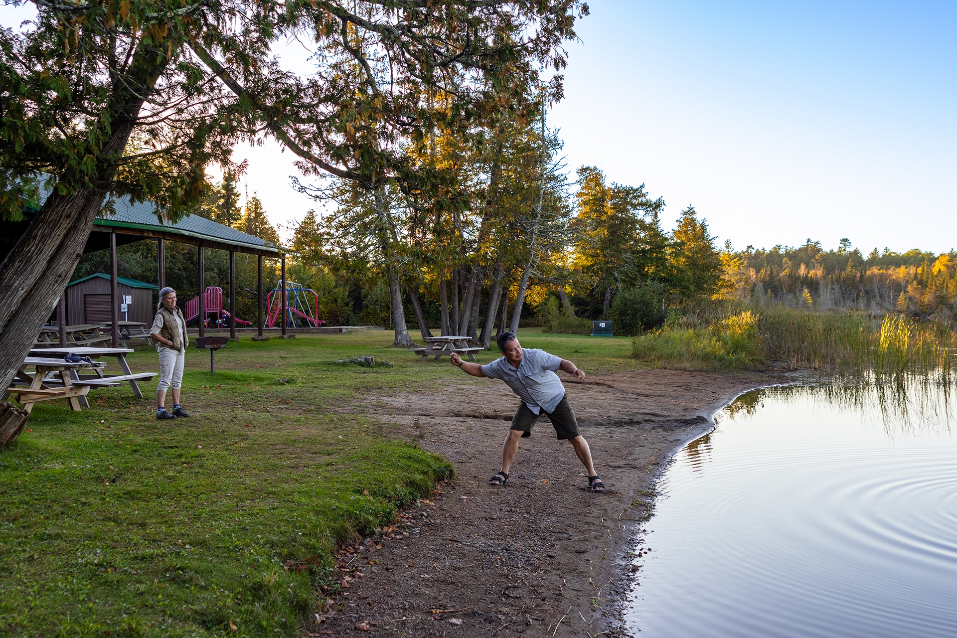 A man prepares to skip a stone across the water
