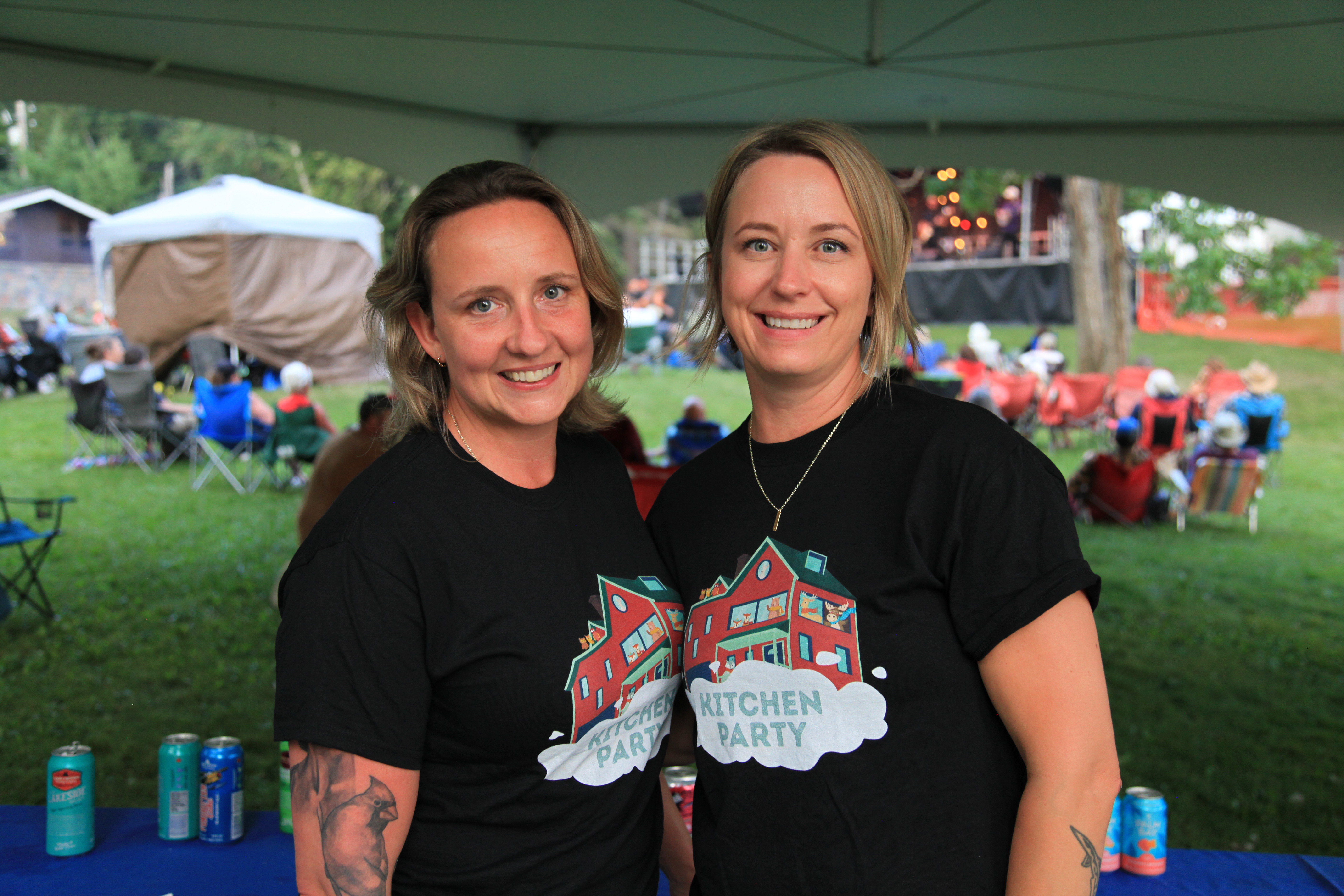 Two women in black t-shirts that read Kitchen Party smile for the camera