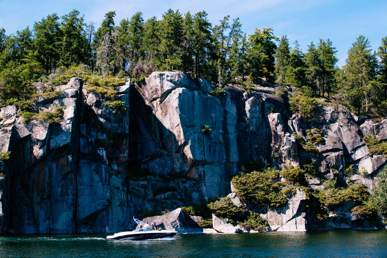 Boat cruising past a cliff